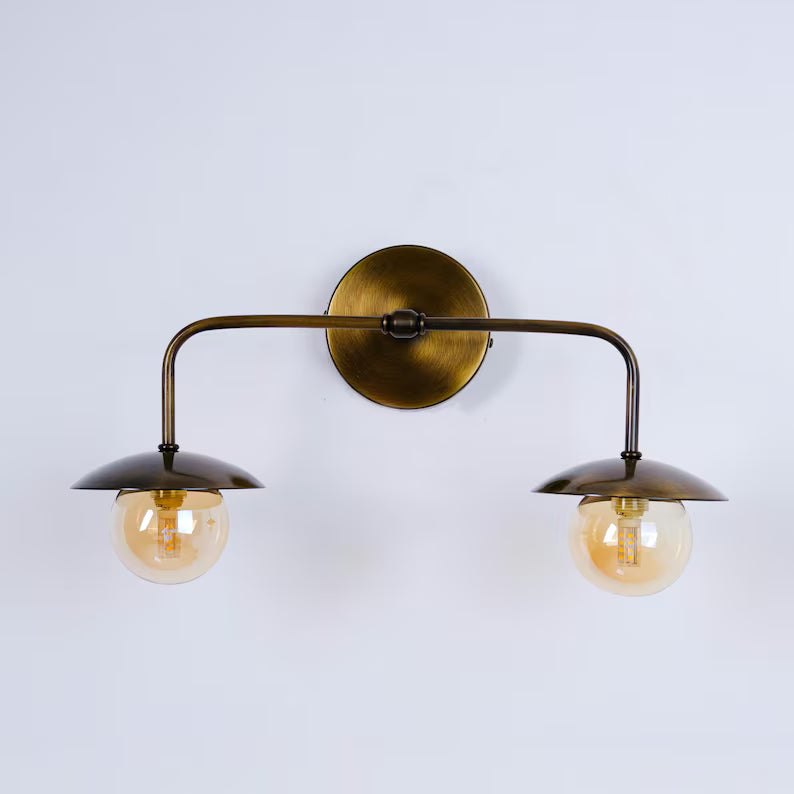 Arandela metálica dourada com lâmpadas decorativas aparentes.